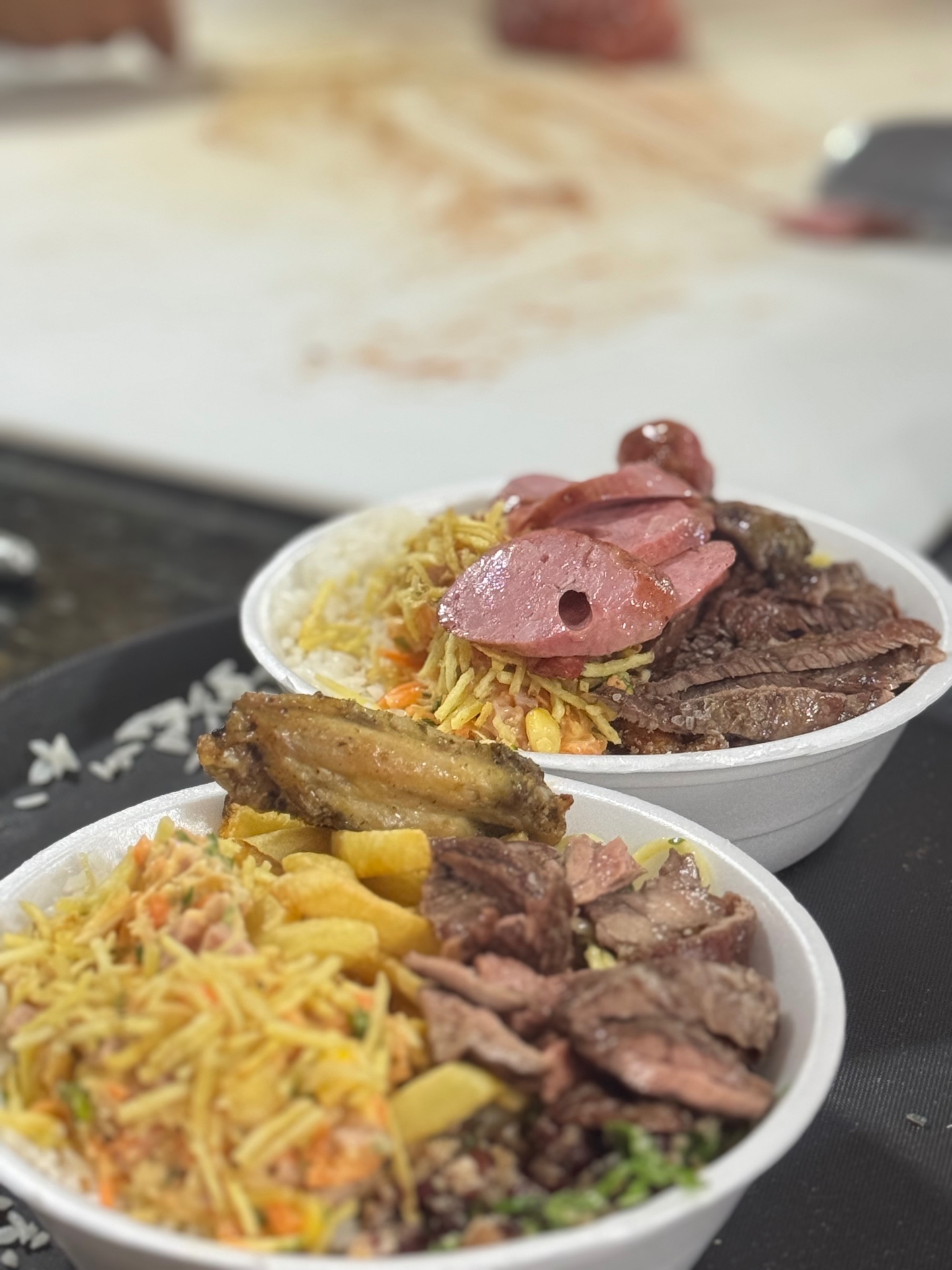 Marmitex e prato feito com carnes e acompanhamentos